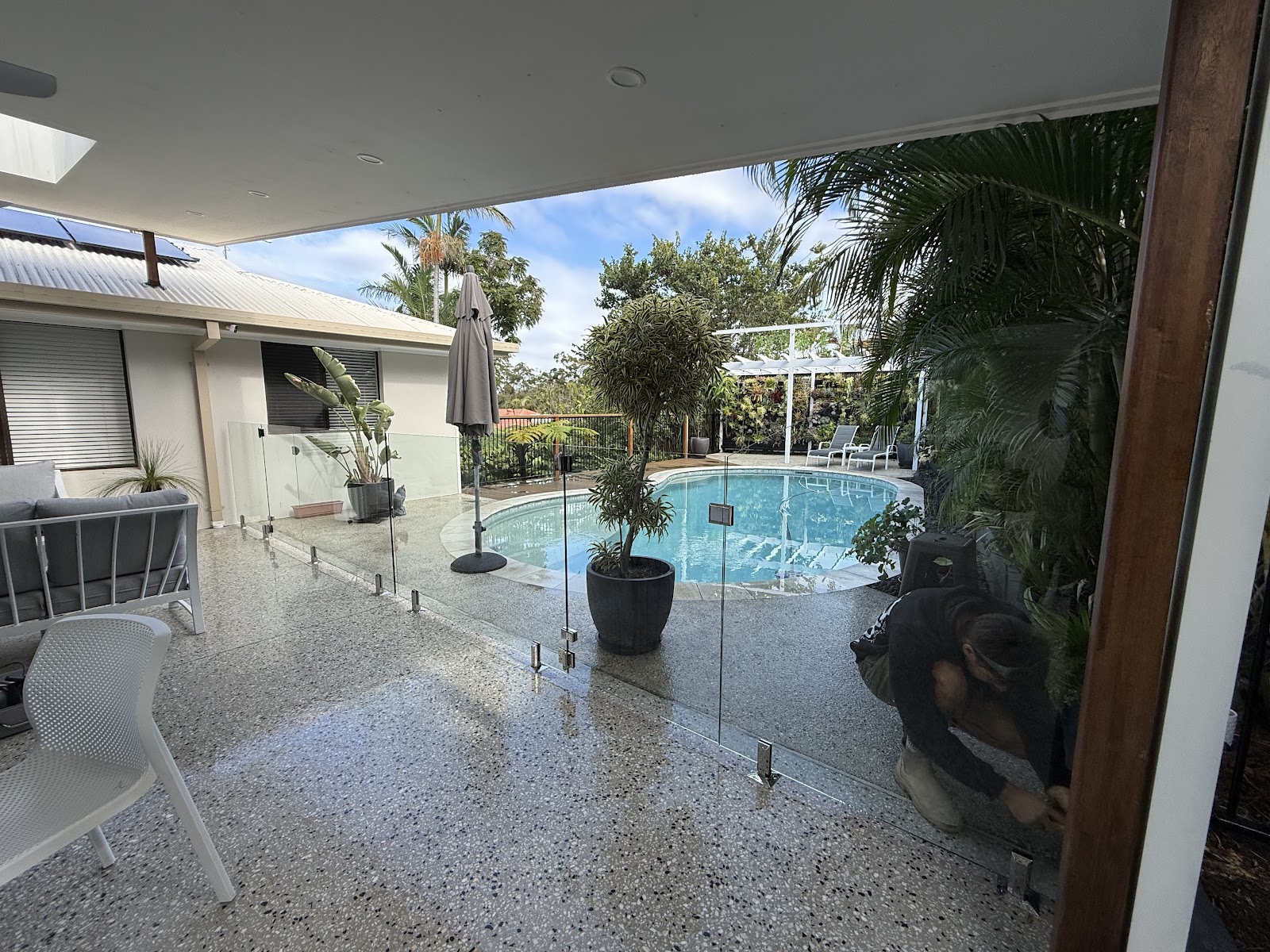 Covered alfresco with a frameless glass fence leading to the pool